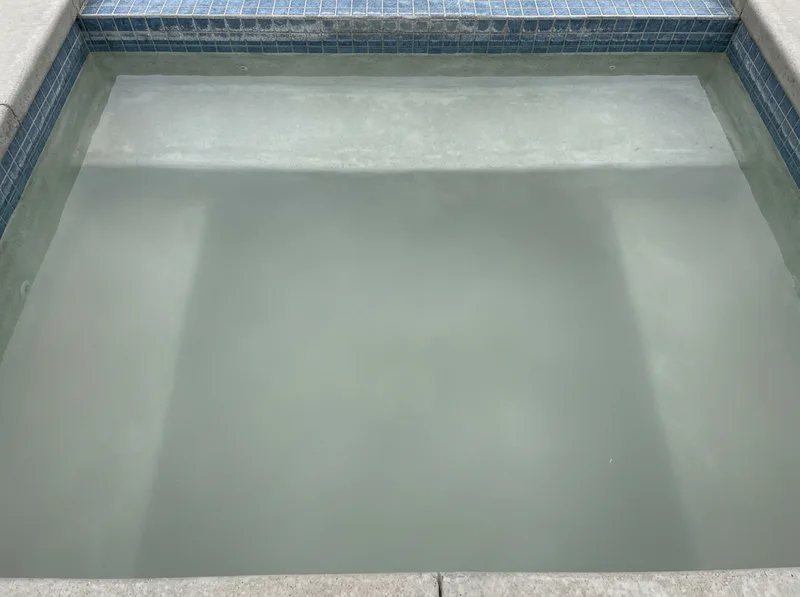 A swimming pool with dull, cloudy water and poor visibility of the floor.